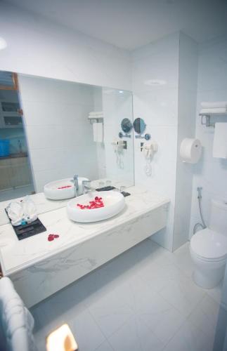 a white bathroom with a sink and a toilet at Canh Hung Palace in Hai Phong
