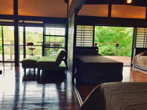 a bedroom with two beds and a chair and a table at Villa yamato in Kumamoto