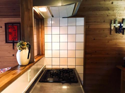 a kitchen with a stove and a vase on the counter at Villa yamato in Kumamoto