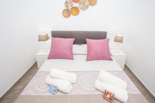 a bedroom with a white bed with pink pillows at Eslanzarote Casa Carait, Super wifi, Sat tv in La Vegueta