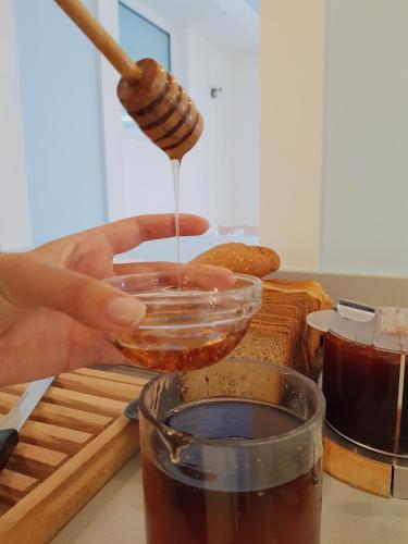 a person is pouring honey into a jar at Porto Plakias & Spa in Plakias