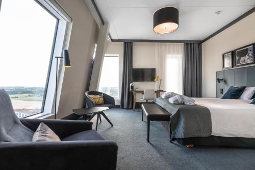 a hotel room with a bed and chairs and a large window at Quality Hotel View in Malmö