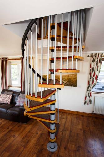 a spiral staircase in a living room with a couch at Lincoln Holiday Retreat Lodge with Private Hot Tub in Lincoln