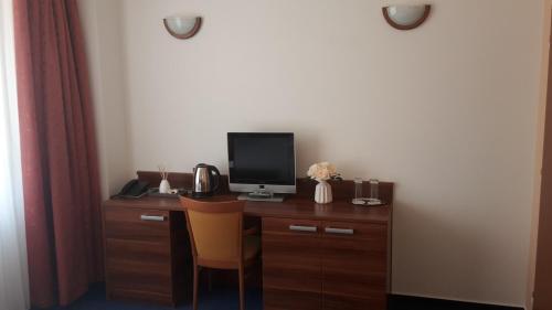 a room with a desk with a tv and a computer at Exclusive HOTEL Lipno Wellness & SPA in Frymburk
