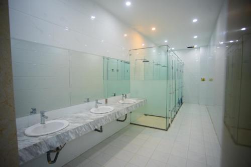 a bathroom with three sinks and a glass shower at Canh Hung Palace in Hai Phong