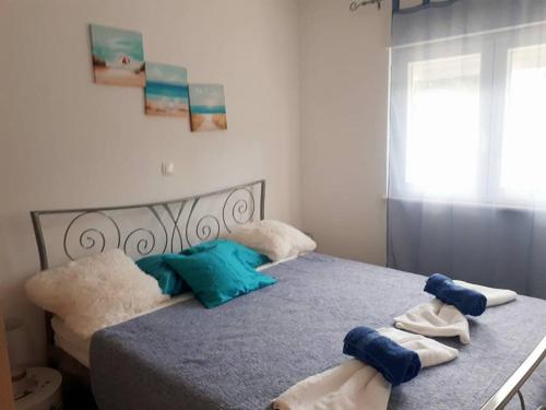 a bedroom with a bed with towels on it at Apartmani Kulin 2 in Kaštela