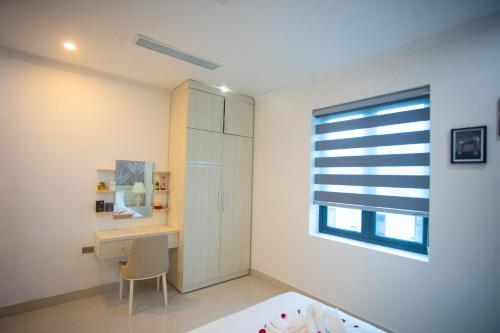 a bedroom with a desk and a window at Canh Hung Palace in Hai Phong