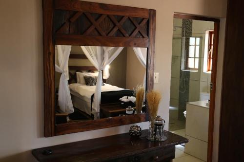 a mirror in a bedroom with a bed and a tub at Auob Country Lodge in Gochas