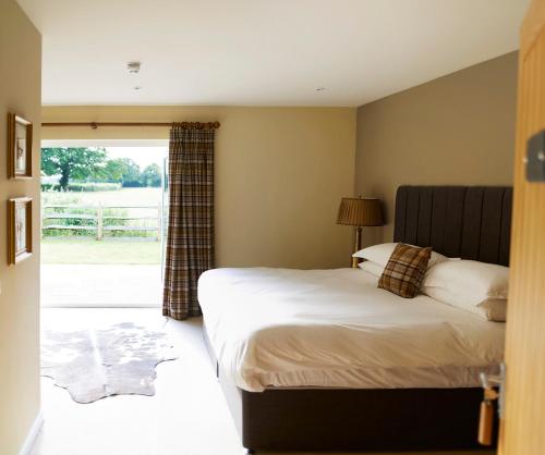 a bedroom with a bed and a sliding glass door at The Three Chimneys Country Pub in Biddenden