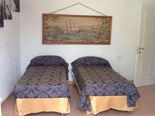 a bedroom with two beds and a painting on the wall at lake house in Mezzanego