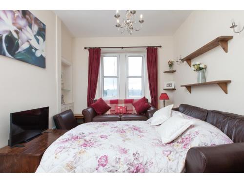 - une chambre avec un lit, un canapé et une fenêtre dans l'établissement Homely Tenement for 2 near Botanic Gardens, à Édimbourg