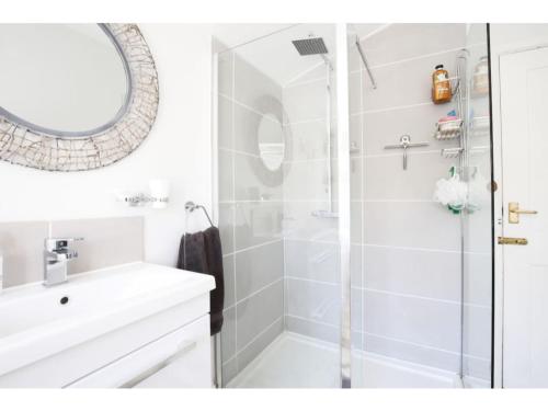 ein weißes Bad mit einer Dusche und einem Waschbecken in der Unterkunft Modern, Chic 2BR Townhouse in Central Oxford in Oxford