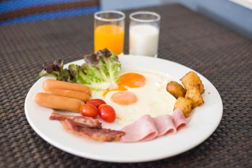 a plate of breakfast food with eggs bacon and vegetables at Loei Palace Hotel in Loei