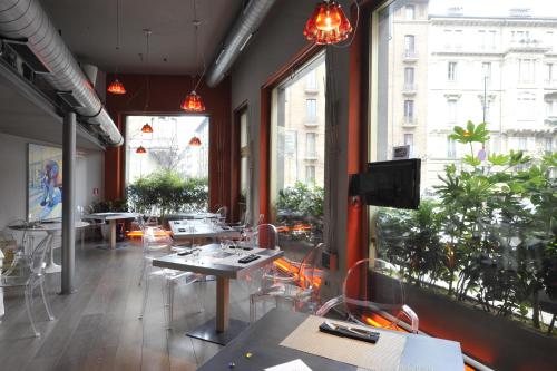 a restaurant with tables and chairs and large windows at Art Hotel Boston in Turin