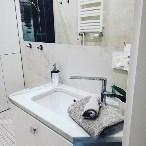 a white bathroom with a sink and a mirror at Softly Residence in Bydgoszcz