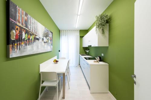una cucina con pareti verdi e tavolo bianco di Angolo Dei Borghi a Castelfranco Veneto