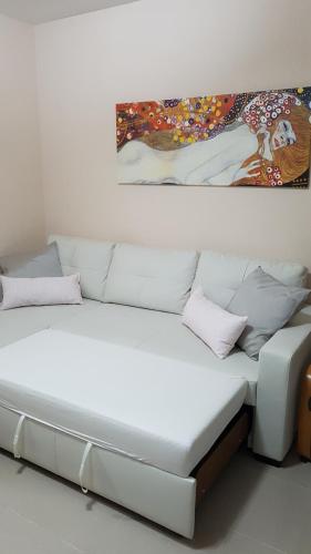 ベナルマデナにあるNueva Torrequebradaの壁画のある部屋の白いソファ