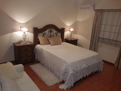 a bedroom with a bed and two lamps and a couch at Casa Das Aguas Ferreas in Estação do Mogadouro