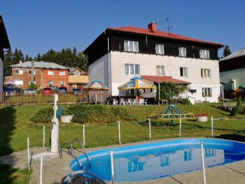 a swimming pool in front of a large building at Hotel - penzion M&M in Jáchymov