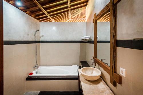 a bathroom with a bath tub and a sink at Sitala Villa in Ubud