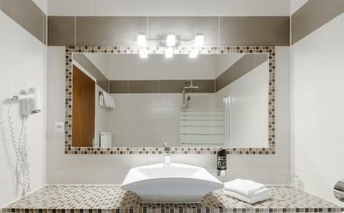 uma casa de banho com um lavatório e um espelho em Pension Hoogerland em Velden am Wörthersee