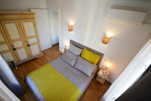 ニースにあるBe our Guests in Nice Port Bonaparteのベッドルーム1室(黄色と灰色の毛布付きのベッド1台付)