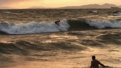 a man riding a wave on a surfboard in the ocean at Best Seaview Attica in Saronida