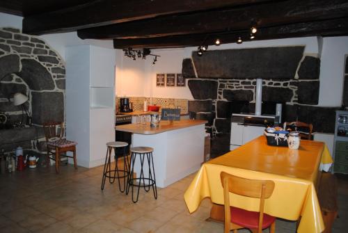 une cuisine avec une table et un chiffon de table jaune dans l'établissement Maison De Famille, à Maël-Pestivien