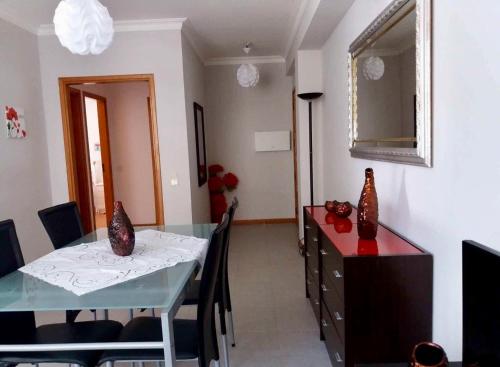 ein Esszimmer mit Tisch und Spiegel in der Unterkunft Apartamento da Praia da Amorosa in Amorosa