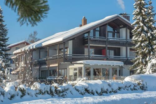 ein großes Gebäude mit Schnee davor in der Unterkunft Steinhausers Hotel Hochbühl in Oberstaufen