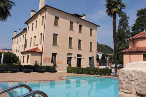 un bâtiment avec une piscine en face d'un bâtiment dans l'établissement Agriturismo Villa Panigai, à Farra di Soligo