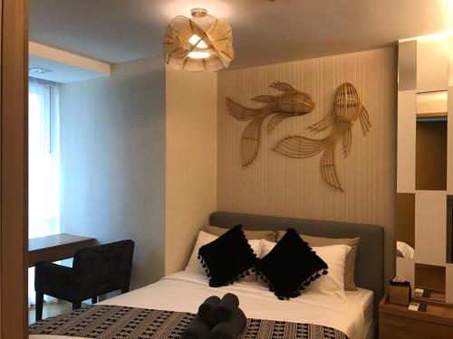 a bedroom with a bed with two pictures on the wall at Everyday Sukhumvit 11-13 Asok Nana Nightlife in Bangkok