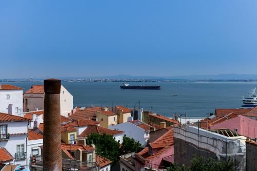 a boat is docked near a large building at Alfama - Lisbon Lounge Suites in Lisbon