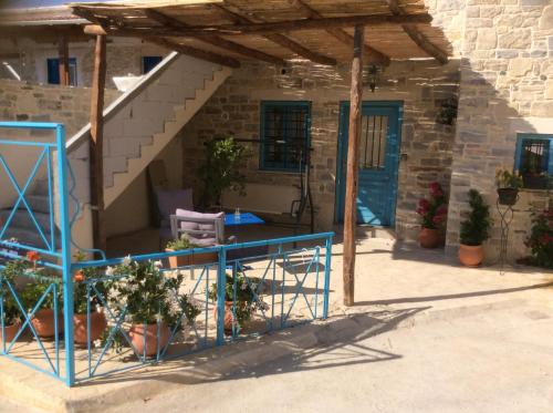 a porch of a house with a blue door at Kritikies Kydonia in Pitsidia