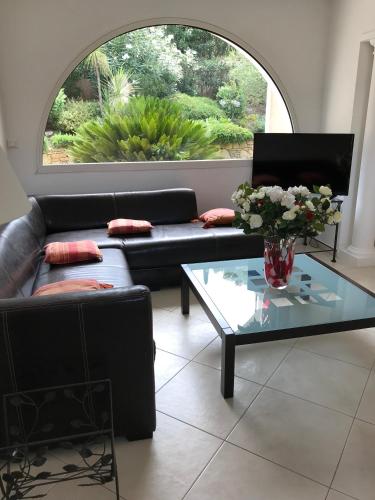a living room with a couch and a glass table at Belle villa dans clos privé - Saint Raphaël Boulouris in Saint-Raphaël