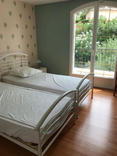 a white bed in a room with a window at Belle villa dans clos privé - Saint Raphaël Boulouris in Saint-Raphaël