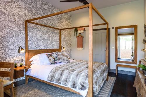 1 dormitorio con cama con dosel en una habitación en The George Inn, en Maulden