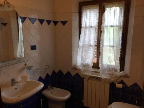 a bathroom with a sink and a toilet and a window at La Vecchia Camera in Montalcino