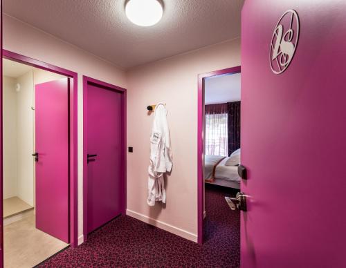 a room with a purple door and a mirror at La Vanoise 1825 in Brides-les-Bains