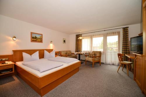 1 dormitorio con 1 cama y sala de estar en Hotel Landhaus Schmid, en Fischen