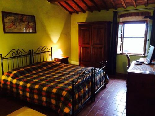 a bedroom with a bed with a checkered blanket at La Vecchia Camera in Montalcino