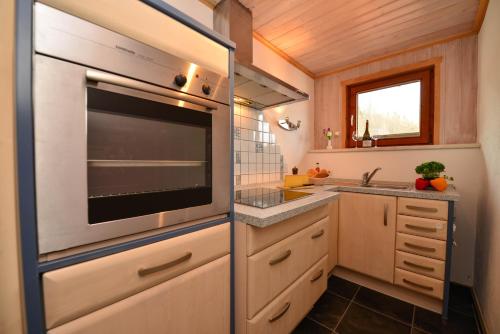 a kitchen with a stainless steel appliance in a tiny house at Hotel Landhaus Schmid in Fischen