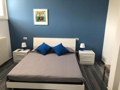 a bedroom with blue walls and a bed with blue pillows at Splendido Loft al mare in Martinsicuro