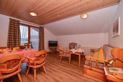 a living room with a table and chairs at Hotel Landhaus Schmid in Fischen