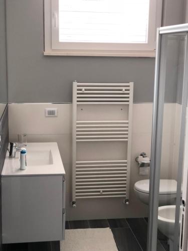 a bathroom with a sink and a toilet and a window at Splendido Loft al mare in Martinsicuro