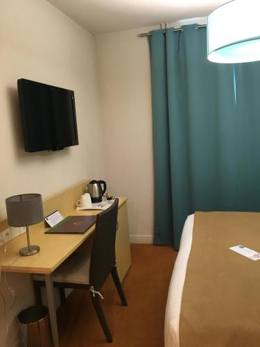 a room with a desk with a bed and a television at Best Western Le Vinci Loire Valley in Amboise