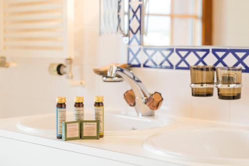 a bathroom sink with two bottles of essential oils on it at Hotel Montpelier in Verbier