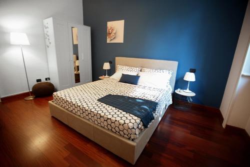 1 dormitorio con cama y pared azul en Quater Apartments - Milano en Milán