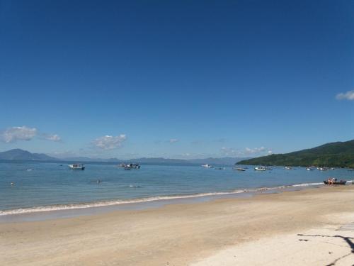 a sandy beach with boats in the water at Vila Alegria in Bombinhas