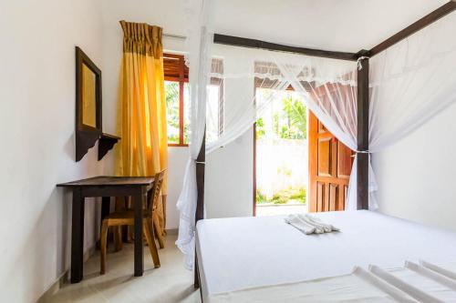 a bedroom with a bed and a window at Cocoplant Surf Inn in Midigama